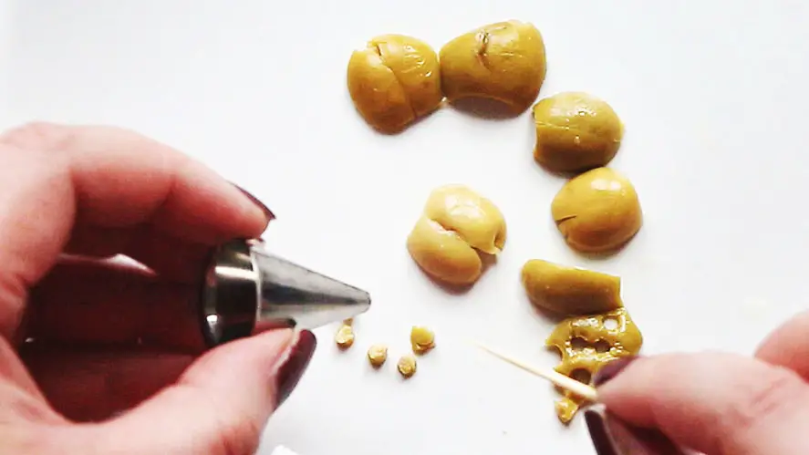 cutting out small circles from olives with a round icing tip
