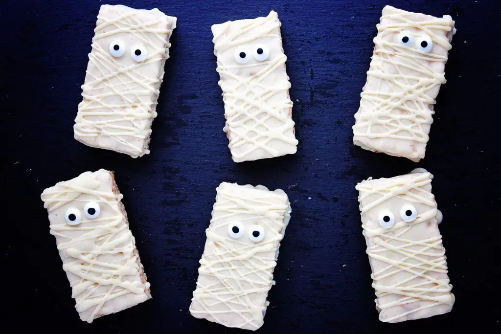 flat lay of Halloween mummy rice krispie treats on a a dark background